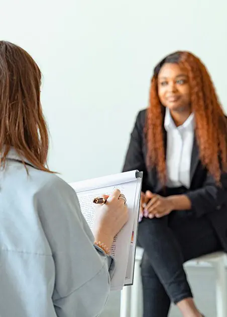 A woman is sitting in front of another person.